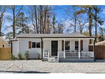 Charming home with white siding, black door, wooden shutters and cozy front porch at 43 Nordan St, Angier, NC 27501