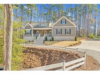 Charming two-story home with a welcoming front porch and well-manicured landscaping nestled in a beautiful wooded area at 4721 Cypress Ford Dr, Fuquay Varina, NC 27526