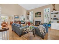 Bright living room features a fireplace, tall ceilings and hardwood floors, creating a cozy atmosphere at 515 Swim & Croquet, Pittsboro, NC 27312