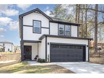 Two story home with black framed windows, a two-car garage, and a grassy front yard at 609 Rawls Dr, Raleigh, NC 27610
