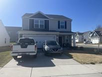 Charming two-story home features a well-maintained lawn, a two-car garage, and a welcoming front porch at 700 Cider Mill Way, Zebulon, NC 27597