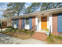Charming brick home with blue shutters, a covered front porch, and a well-manicured front yard at 914 S Crescent Dr, Smithfield, NC 27577