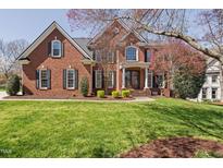 Stately brick home with lush lawn, mature trees, and covered entrance offers timeless elegance at 101 Listokin Ct, Cary, NC 27519