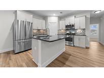 Modern kitchen features stainless steel appliances, center island, and stylish backsplash at 1103 Apogee Dr, Durham, NC 27713