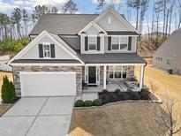 Charming two-story home featuring a covered porch and a stone-accented facade, offering great curb appeal at 115 Cliffview Dr, Garner, NC 27529