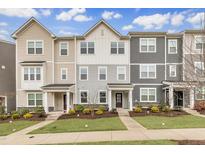 Charming townhome exteriors featuring varied siding and manicured lawns set against a bright, partly cloudy sky at 1434 Rosepine Dr, Cary, NC 27519