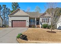 Charming one-story home with a well-maintained lawn, attached garage, and inviting front porch at 153 Brindley Cir, Clayton, NC 27520