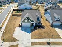 Aerial view of a single Gathering home featuring a two car garage, manicured yard, and neighborhood park at 201 Lingonberry Dr, Holly Springs, NC 27540