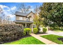 Charming two-story home features a well-manicured lawn and inviting covered front porch at 2208 Fullwood Pl, Raleigh, NC 27614