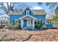 Charming two-story blue home featuring a covered front porch and a well-maintained yard at 290 Collie Rd, Castalia, NC 27816
