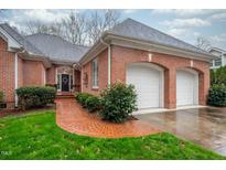 Charming brick home featuring an attached two car garage and a brick walkway at 306 Lancaster Dr, Chapel Hill, NC 27517