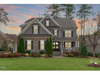 Charming two-story home with stone accents, manicured lawn, and inviting front porch at 3608 Hillthorn Ln, Apex, NC 27539