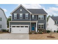 Charming two-story home featuring gray siding, black shutters, and a bright blue front door at 3727 Horton Hill Dr, New Hill, NC 27562