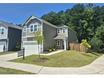 Charming two-story home with a garage, well-manicured lawn, and beautiful landscaping at 4000 Passenger Pl, Durham, NC 27703