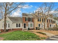Charming townhomes showcasing brick and siding exteriors, neat landscaping, and inviting front entrances on a sunny day at 4524 Hamptonshire Dr, Raleigh, NC 27613
