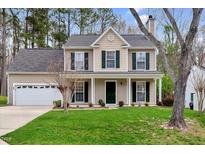 Charming two-story home featuring a well-manicured lawn and a two-car garage at 5512 Cardinal Grove Blvd, Raleigh, NC 27616