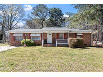 Charming brick home with well-maintained lawn and inviting front porch at 5630 Jones Sausage Rd, Garner, NC 27529