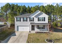 Charming two-story home featuring gray siding, black shutters, a well-kept lawn, and an attached garage at 709 Conifer Ct, Creedmoor, NC 27522