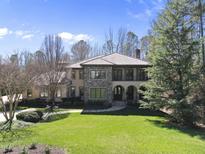 Stunning two-story home features a tile roof and stone accents, nestled on a sprawling green lawn at 7504 Everton Way, Wake Forest, NC 27587