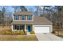 Charming two-story home featuring a well-maintained lawn, two-car garage, and inviting blue front door at 80 Westbrook Ln, Franklinton, NC 27525