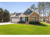 Charming home with blue siding, stone accents, and a bright yellow front door at 923 Sagamore Dr, Louisburg, NC 27549