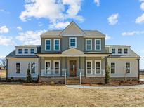 Two-story home with a welcoming front porch and manicured yard at 109 Little Lady Trail, Zebulon, NC 27597