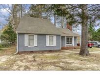 Charming single-story house with gray siding, white trim, and mature trees in a quiet setting at 1100 Cardinals Knob, Rocky Mount, NC 27804