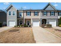 Charming townhome featuring a well-manicured lawn, attached garages, and diverse architectural accents at 116 Polaris Ave, Garner, NC 27529