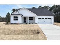 Charming white home with a two-car garage and a well-manicured lawn at 136 Tee Time Ter, Benson, NC 27504