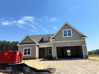New construction home features neutral siding, double garage, dormer windows and classic architectural details at 141 Noramac Ct, Selma, NC 27576