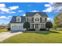 Charming two-story home with a well-manicured lawn, two-car garage, and attractive landscaping at 154 Ashton Ln, Angier, NC 27501