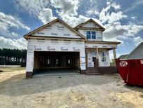 New construction home featuring a two-car garage and brick-accented entry, under construction, with a blue sky backdrop at 163 Noramac Ct, Selma, NC 27576