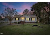 Charming single-story home with a well-manicured lawn and classic curb appeal at dusk at 1809 Beech Ct, Burlington, NC 27217