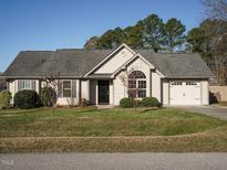 Charming one-story home with well-manicured lawn, attached garage, and classic architectural details at 216 Orkney Rd, Stem, NC 27581