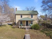 Charming two-story home with a covered front porch and a well-maintained lawn at 2409 Hodges Rd, Burlington, NC 27217