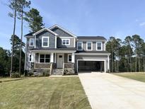 Beautiful two-story home with stone accents, a covered porch, and an attached two-car garage at 266 Golfview Ave, Benson, NC 27504