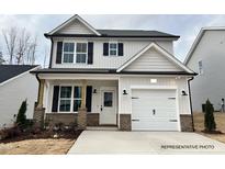 Charming two-story home showcasing a well-manicured lawn and a welcoming entrance, with a white garage door at 354 Bluejay St, Clayton, NC 27520
