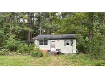Cozy cottage-style home featuring a quaint front entrance and surrounded by mature trees at 3541 Holden Acres Dr, Wendell, NC 27591