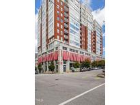 Stunning condominium building featuring red brick accents, balconies, and a retail space with red awnings at 400 W North St # 1204, Raleigh, NC 27603
