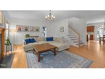 Bright living room features hardwood floors, a decorative rug, a sectional sofa, and a modern light fixture at 445 S Greensboro St, Carrboro, NC 27510