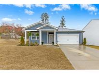 Charming one-story home with a manicured lawn and inviting front porch at 501 Campbell Ridge Pl, Wendell, NC 27591