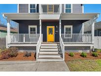 Inviting home featuring a bright yellow front door and a charming white railed porch at 613 Canal St, Durham, NC 27701