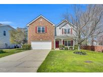 Charming two-story home featuring a brick facade, red shutters, a well-maintained lawn, and a two car garage at 6817 Osprey Landing Dr, Wendell, NC 27591