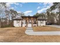Inviting white brick home with stylish porch and landscaping, offering great curb appeal at 703 Sybil Dr, Durham, NC 27703