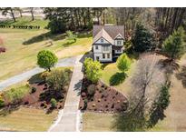 Beautiful two-story home featuring lush landscaping, mature trees, and a long driveway leading up to the house at 913 Clayton Rd, Angier, NC 27501