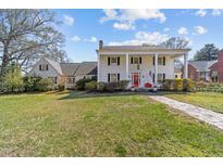 Stately two-story home with white columns, a red front door, and a brick walkway at 1106 Aycock Ave, Burlington, NC 27215