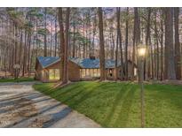 Charming single-story brick home with well-manicured lawn and mature trees, exuding curb appeal and natural beauty at 11808 Black Horse Run, Raleigh, NC 27613