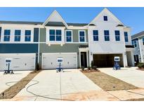 View of townhomes with varied exteriors and attached garages and driveways on a sunny day at 158 Nimble Way # 226, Clayton, NC 27520