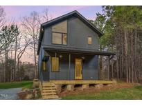 Modern two-story home featuring a metal roof, expansive windows, and inviting front porch at 168 Daphine Dr, Hillsborough, NC 27278