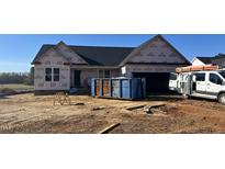 New construction home featuring a two-car garage and covered front porch awaiting finishing touches at 207 N Movado Trl, Kenly, NC 27542